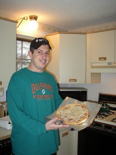 bob shows off a cheese pizza